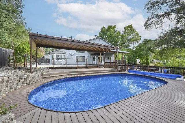 a swimming pool with outdoor seating and yard