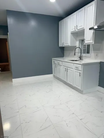 a kitchen with granite countertop white cabinets and stainless steel appliances