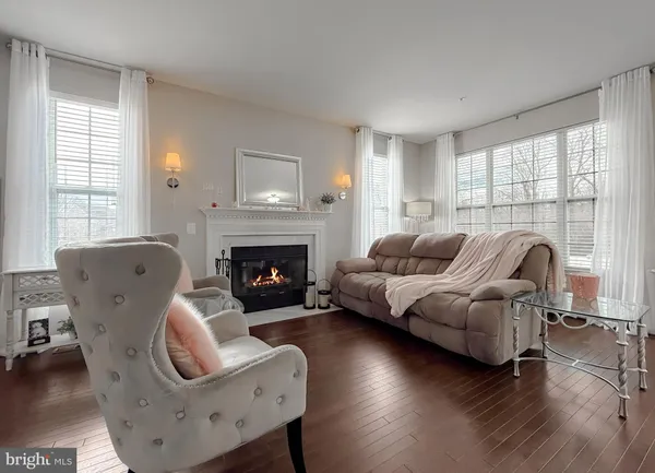 a living room with furniture a fireplace and a large window