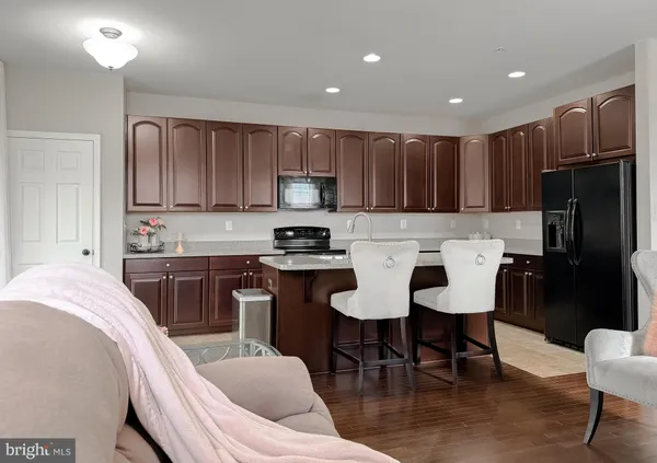 a kitchen with a dining table chairs refrigerator and cabinets