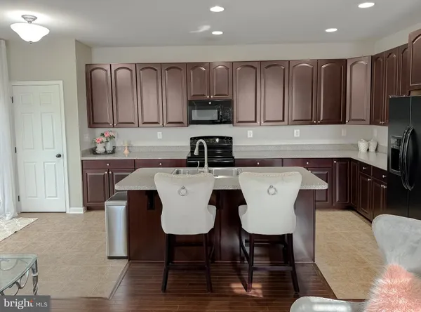 a kitchen with a stove a sink a counter space and a dining table with wooden floor
