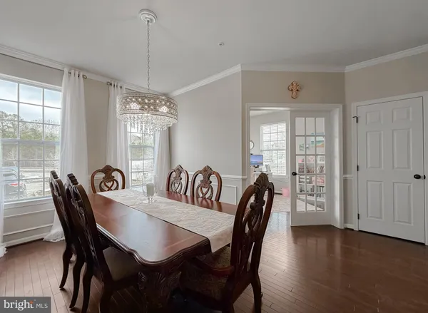 a view of a a dining room with furniture window and wooden floor