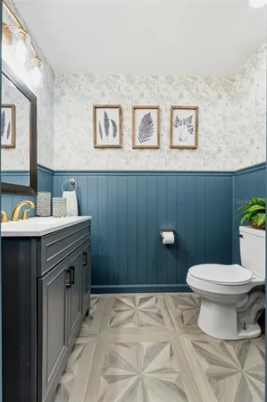 a bathroom with a granite countertop toilet sink and mirror