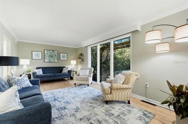 a dining room with furniture a chandelier and kitchen view