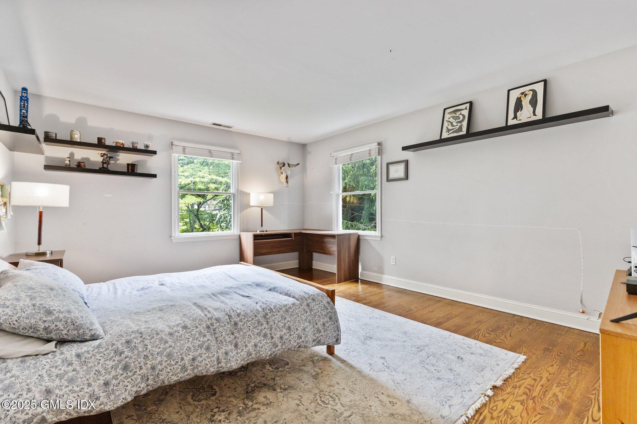 4 Tyler Lane Riverside, CT 06878 - Photo 18 of 27 a bedroom with a bed and wooden floor