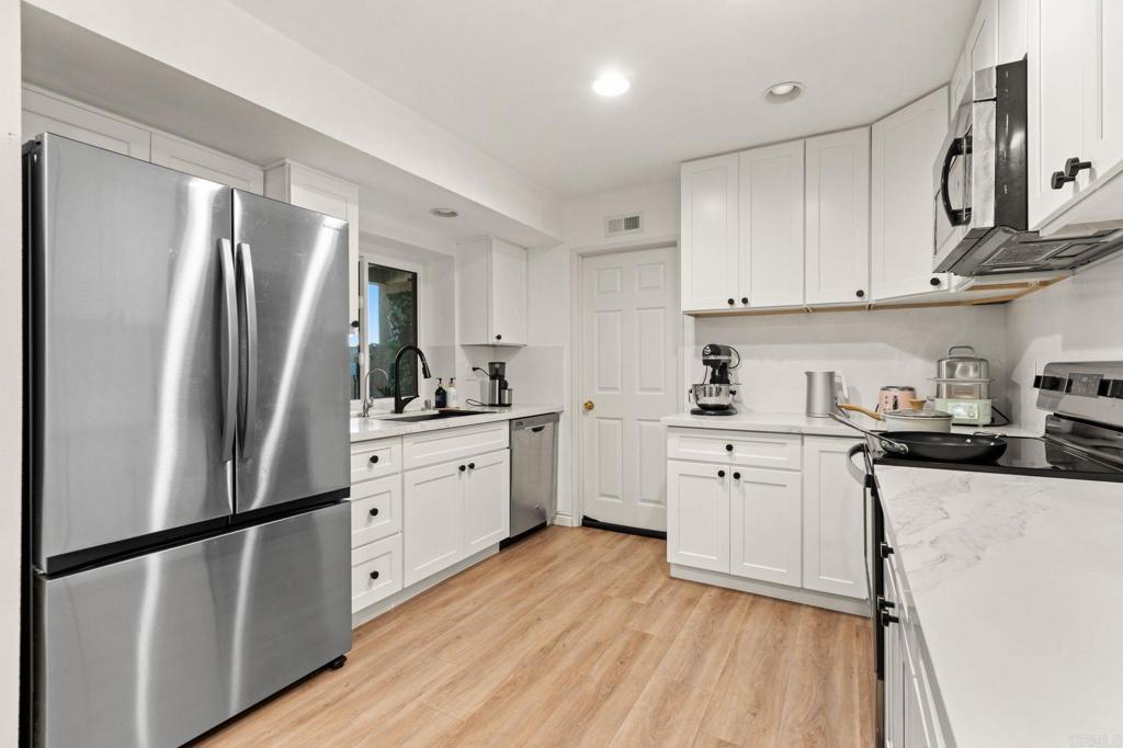17597 Fairlie Road San Diego, CA 92128 - Photo 4 of 15 a kitchen with stainless steel appliances a refrigerator sink and cabinets
