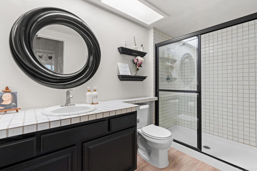 17597 Fairlie Road San Diego, CA 92128 - Photo 9 of 15 a bathroom with a toilet a sink and mirror