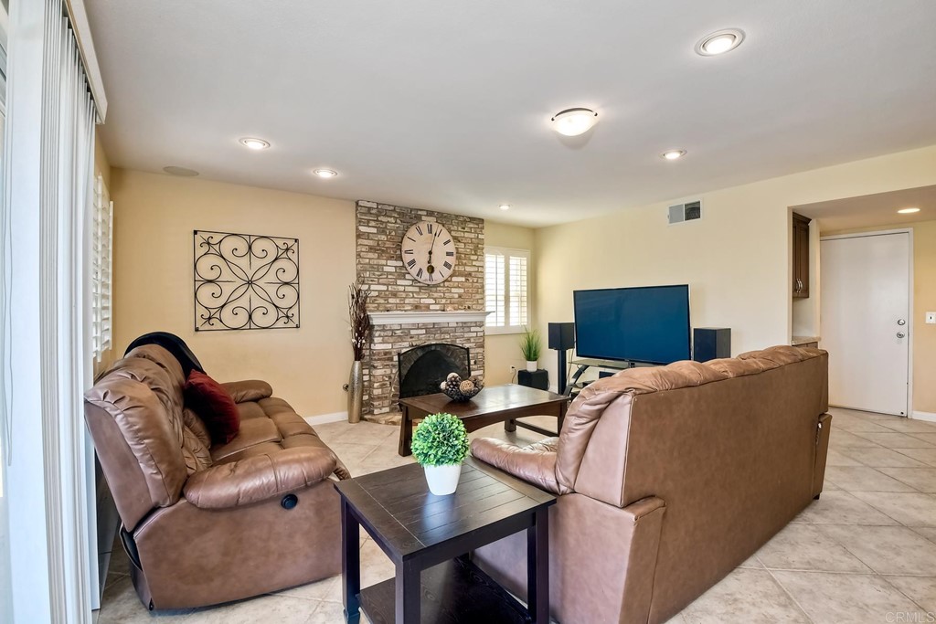 2754 Olympia Drive Carlsbad, CA 92010 - Photo 12 of 35 a living room with furniture a fireplace and a flat screen tv