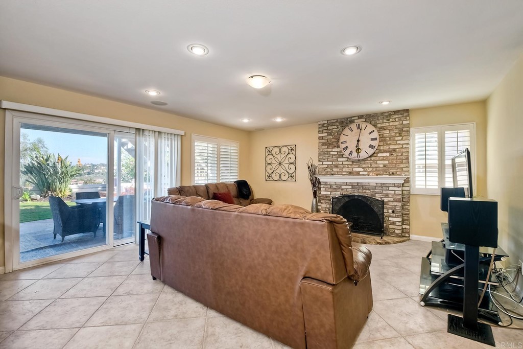 2754 Olympia Drive Carlsbad, CA 92010 - Photo 13 of 35 a living room with furniture a fireplace and a flat screen tv