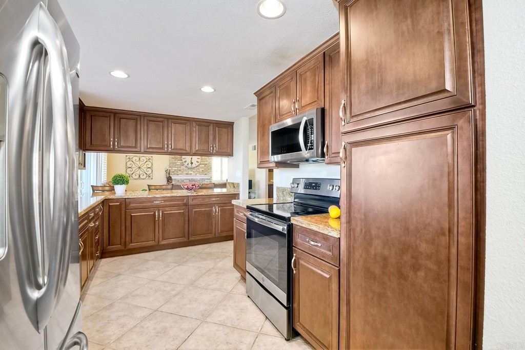 2754 Olympia Drive Carlsbad, CA 92010 - Photo 8 of 35 a kitchen with stainless steel appliances granite countertop a refrigerator a stove top oven a sink and dishwasher