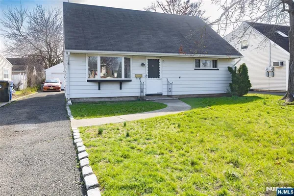 a front view of a house with a garden and plants