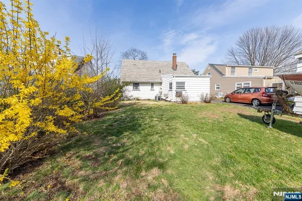 a view of a house with a big yard and large trees