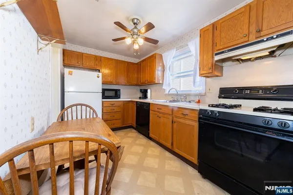 a kitchen with stainless steel appliances granite countertop a stove a sink dishwasher and a stove top oven with wooden floor