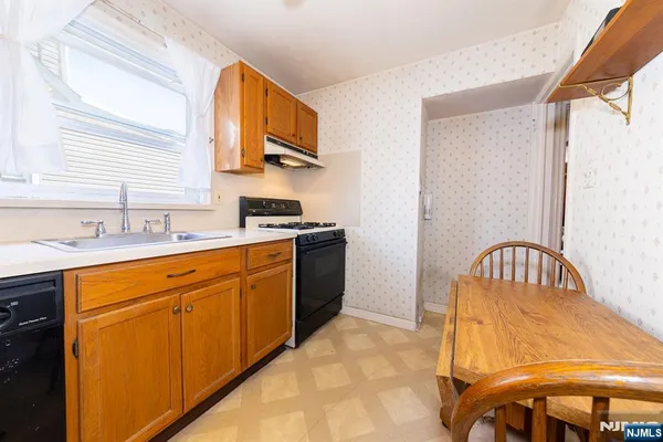 a kitchen with stainless steel appliances granite countertop a sink a stove and a refrigerator