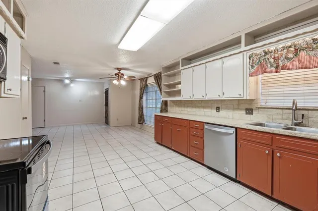 a large kitchen with stainless steel appliances granite countertop a sink and cabinets