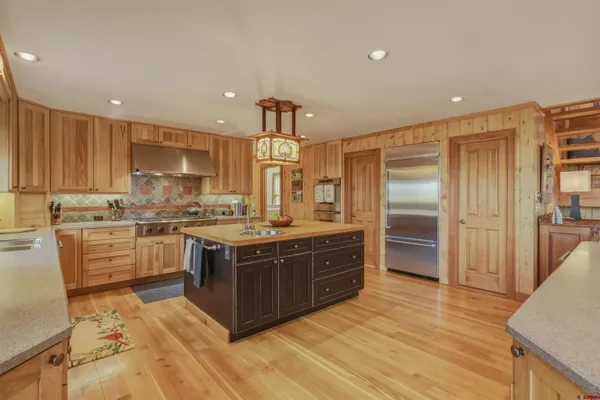 a large kitchen with stainless steel appliances granite countertop a stove and a refrigerator