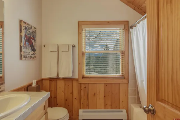 a bathroom with a granite countertop sink and a toilet