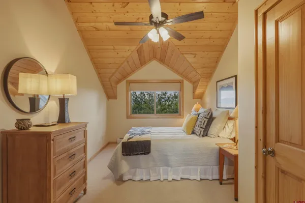 a bedroom with a bed a mirror and a window