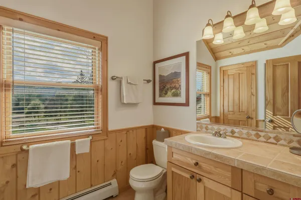 a bathroom with a granite countertop sink toilet and mirror