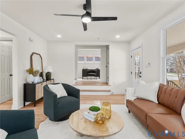 a view of a livingroom with furniture a fireplace chandeliers fan