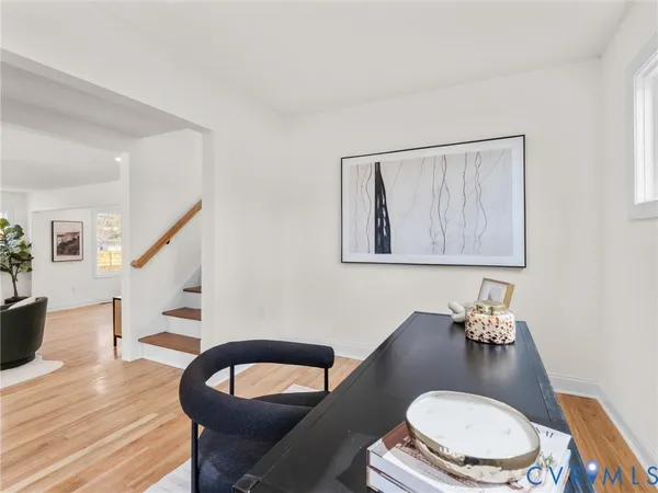 a kitchen with stainless steel appliances kitchen island granite countertop a dining table chairs and a refrigerator