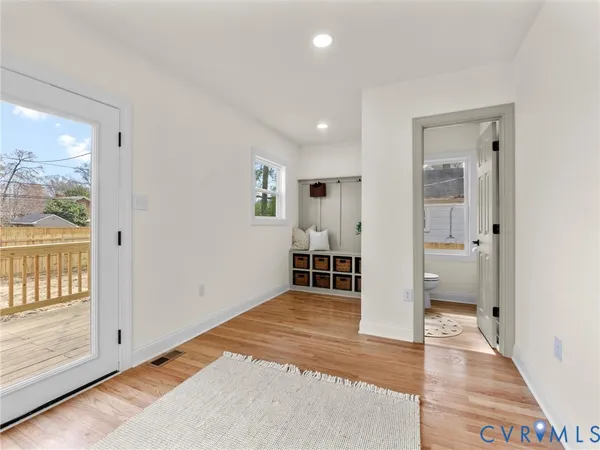 an empty room with wooden floor and windows