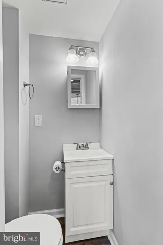 a bathroom with a toilet sink vanity and mirror