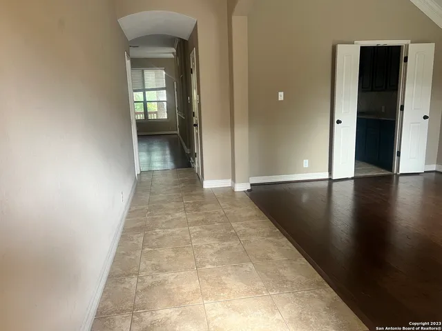 a view of a hallway with wooden floor and a living room