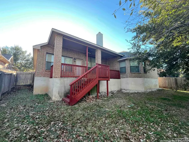 a view of a house with a yard and large tree