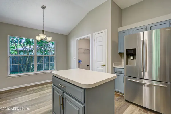 a kitchen with a refrigerator a sink and dishwasher with wooden floor