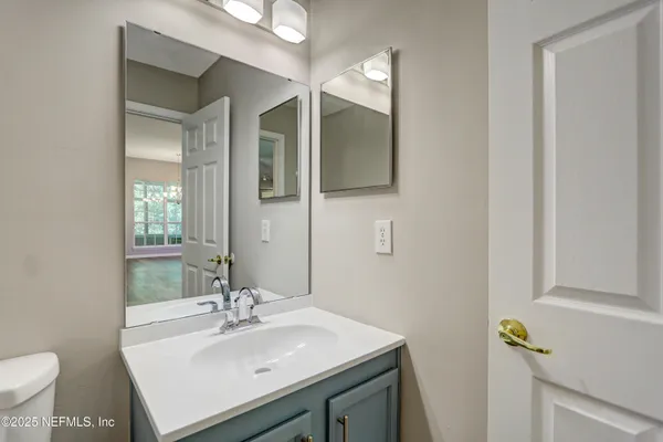 a bathroom with a sink and a mirror with toilet