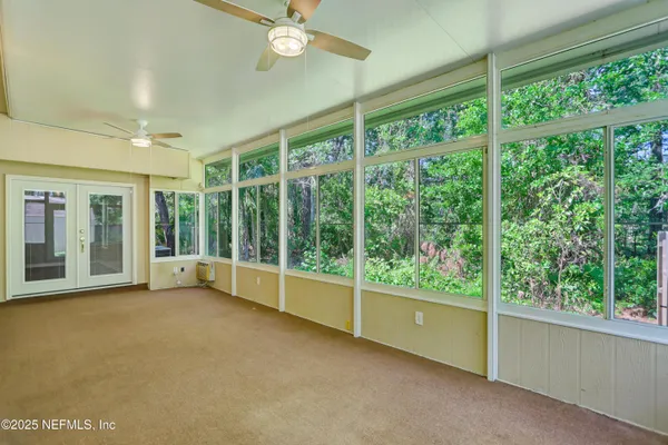 a view of an empty room with windows and balcony