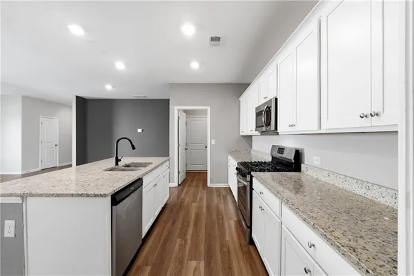 a kitchen with white cabinets and stainless steel appliances