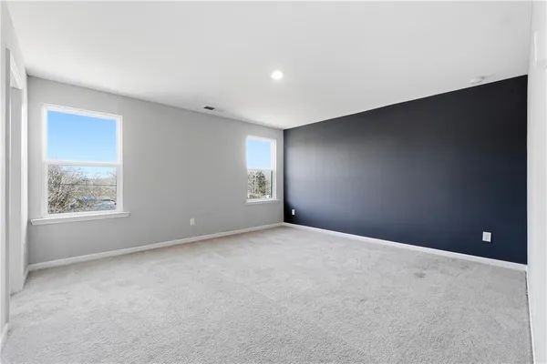 an empty room with windows and closet