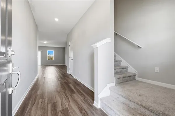 a view of a hallway with wooden floor and staircase
