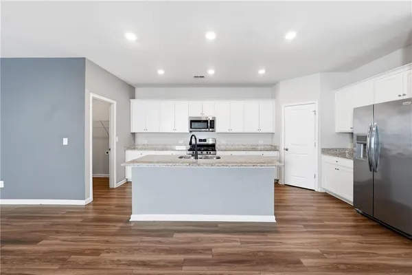 a kitchen with stainless steel appliances granite countertop a sink stove and refrigerator