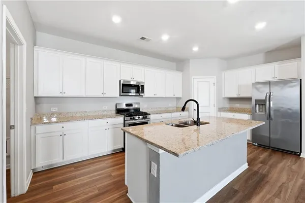 a kitchen with stainless steel appliances a refrigerator sink and cabinets