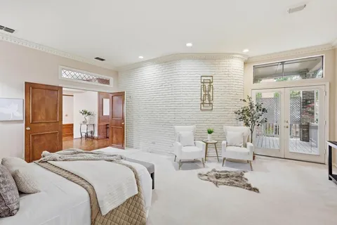 a bedroom with a large bed and glass windows