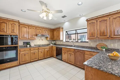 a kitchen with stainless steel appliances granite countertop a sink dishwasher stove top oven and cabinets