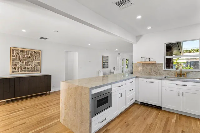 a kitchen with granite countertop white cabinets and white appliances