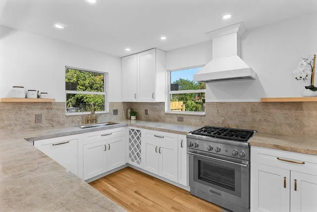 a kitchen with a stove a sink and a window