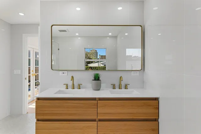 a bathroom with a sink a large mirror and shower