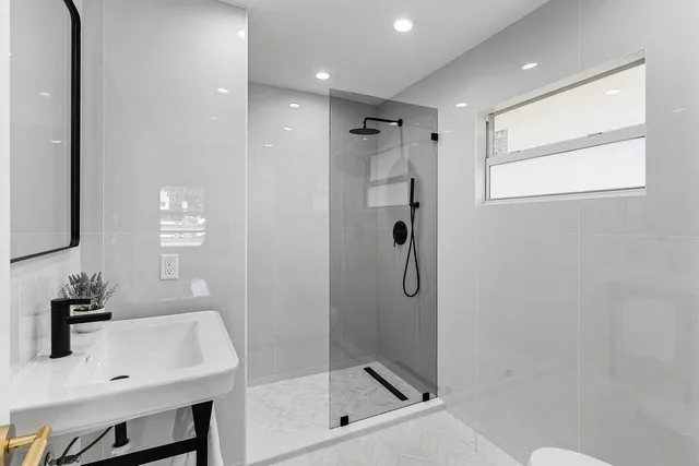 a bathroom with a shower a sink and a mirror