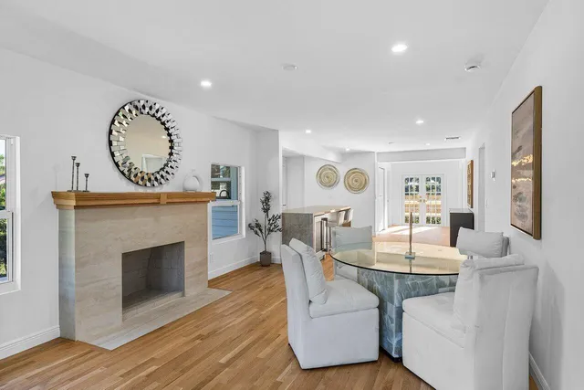 a dining room with furniture a fireplace and wooden floor