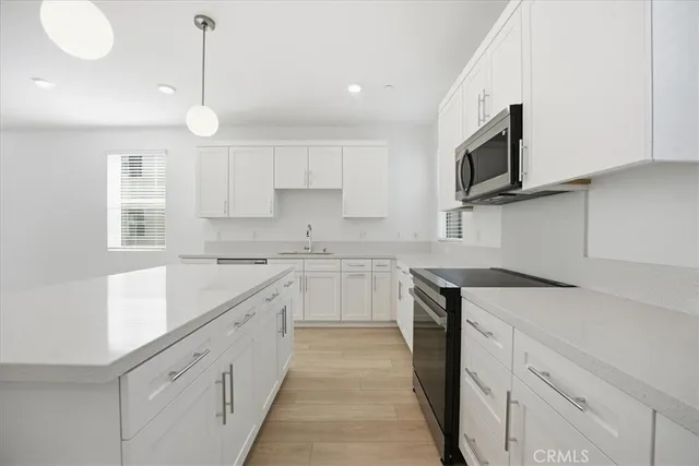 a kitchen with cabinets appliances a sink and a counter top space