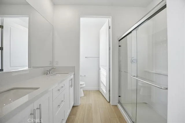 a bathroom with a granite countertop sink a toilet and a shower