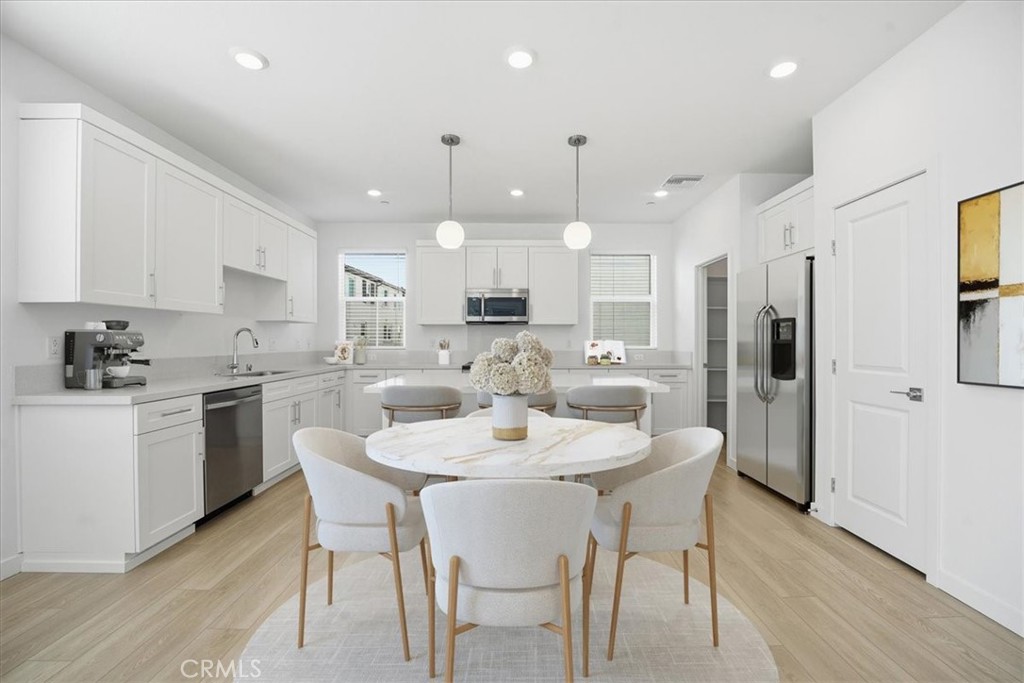 9324 Via Azul Pico Rivera, CA 90660 - Photo 8 of 33 a kitchen with a dining table chairs refrigerator and cabinets