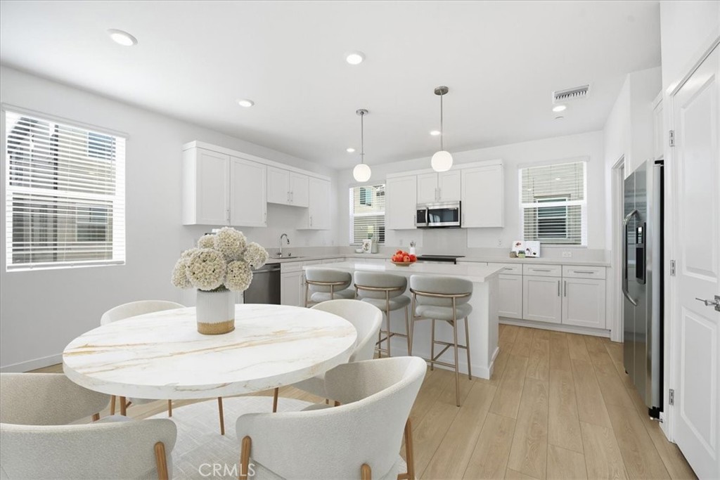 9324 Via Azul Pico Rivera, CA 90660 - Photo 10 of 33 a kitchen with a dining table chairs and refrigerator