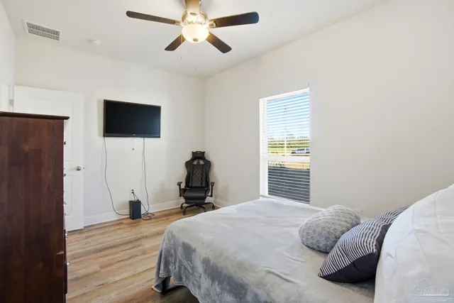 a bedroom with a bed and wooden floor