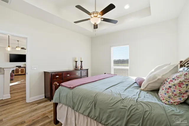 a kitchen with stainless steel appliances granite countertop a stove a sink and white cabinets with wooden floor